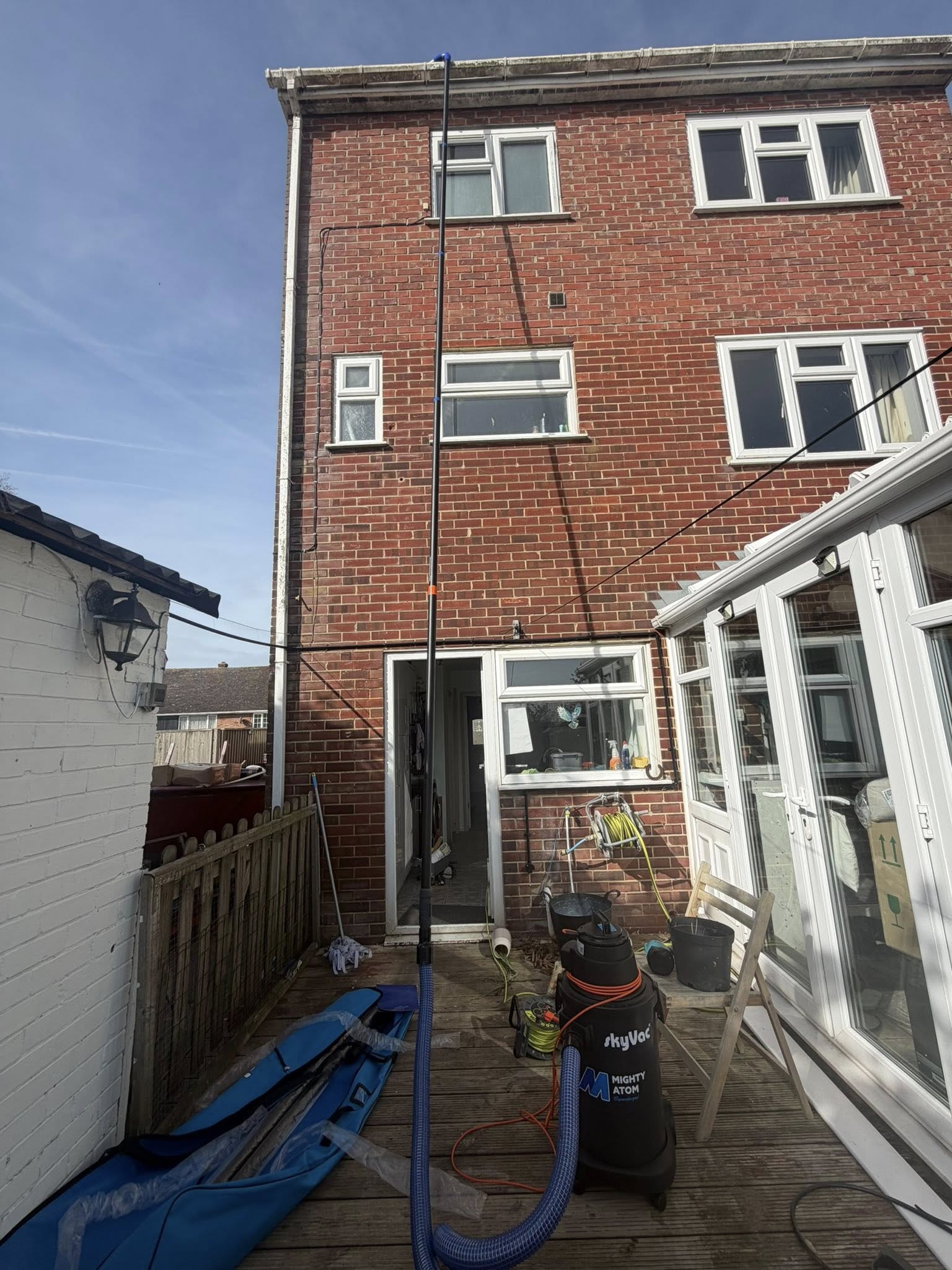 Residential patio with cleaning equipment and hose setup